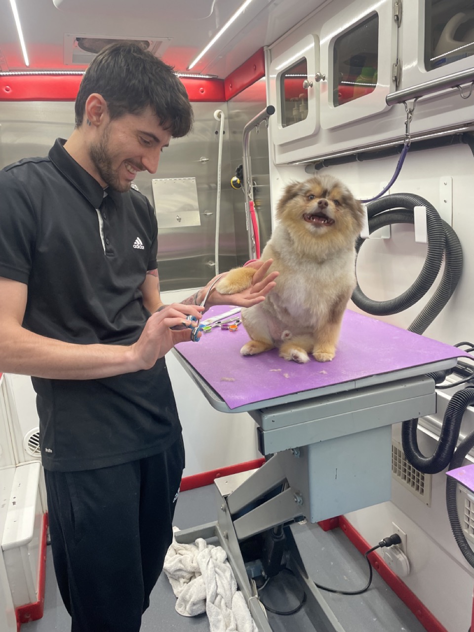 Ben celebrating graduation with certificate in front of the van