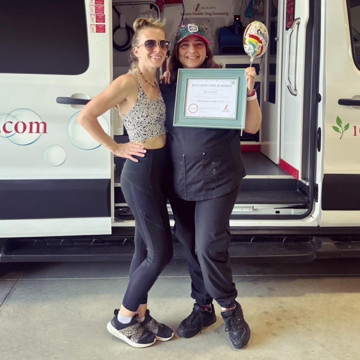 Divya posing with an instructor outside the grooming van